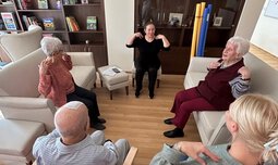 Mehrere Senioren und Seniorinnen sitzen in einem Kreis und machen gemeinsam Übungen | © Caritas München und Oberbayern